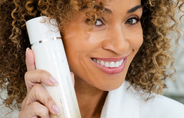 Image of woman holding a bottle of ProLuxe Rebalancing Conditioner.